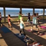 Attendees practicing yoga at Jenny's yoga retreat overlooking the ocean.